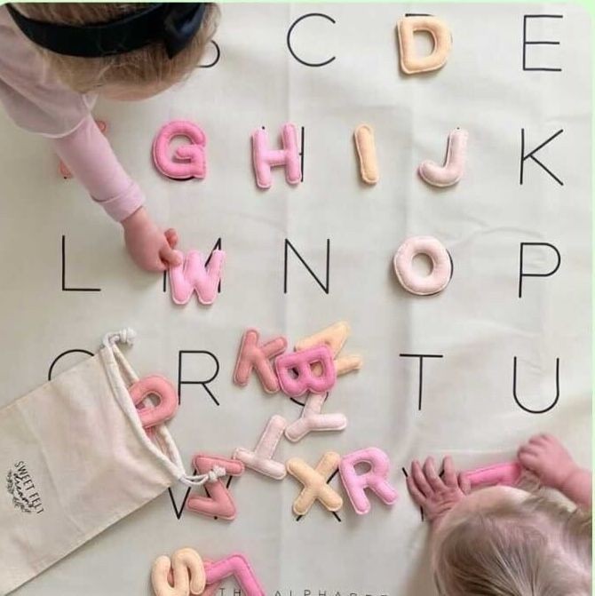 toddlers playing with alphabet letters